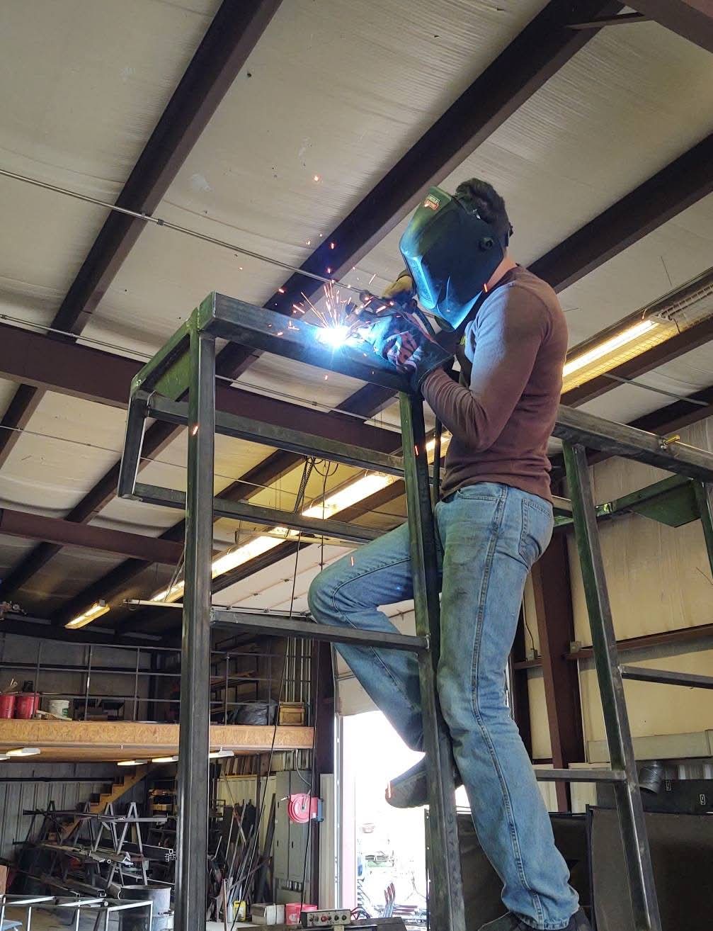 Welder working on an elevated steel frame