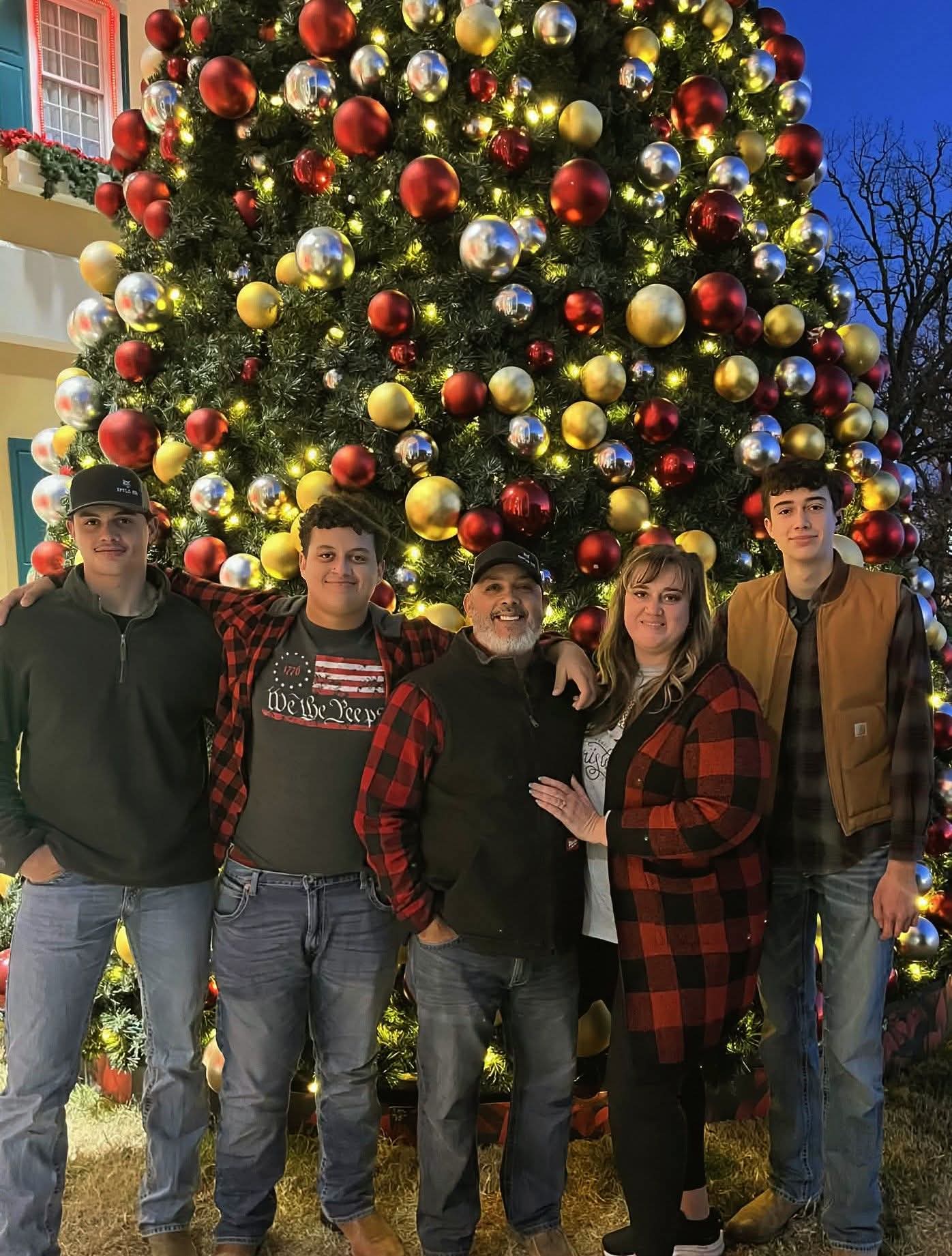 The Irizarry family in front of a decorated Christmas tree